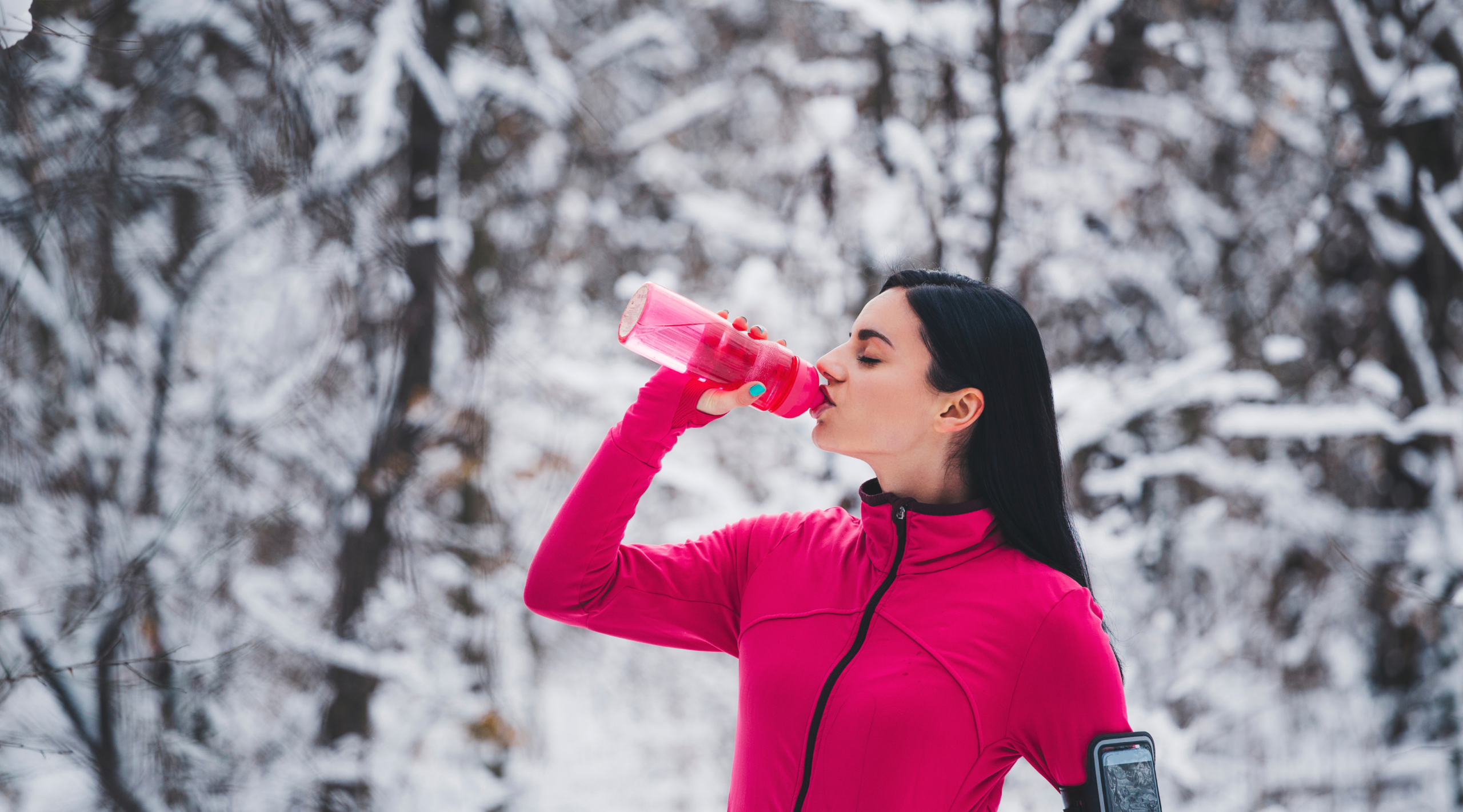 lady drinking water outside in the wintertime
